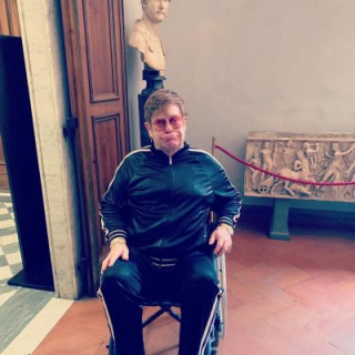 Elton John appears in a wheelchair