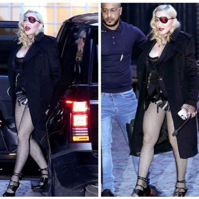 Madonna walks in a corset, almost revealing the chest