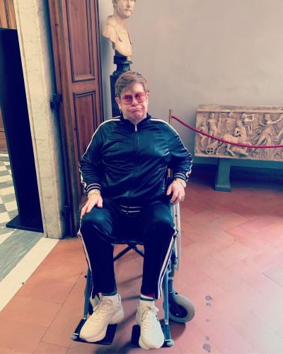 Elton John appears in a wheelchair